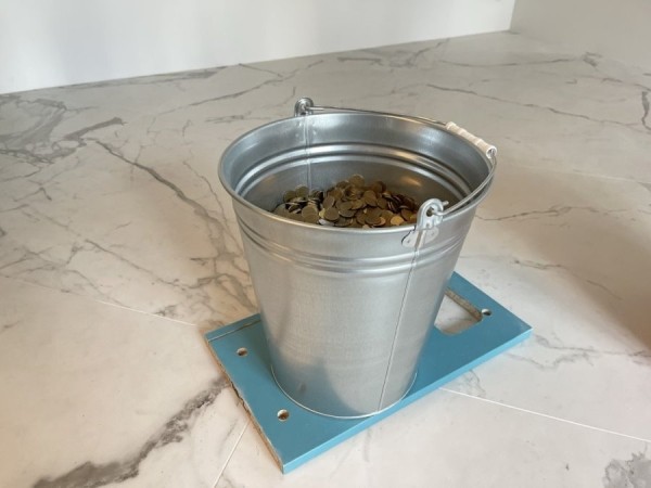 «За 3 часа посчитали только половину». Парень принес 12-литровое ведро монет в банк